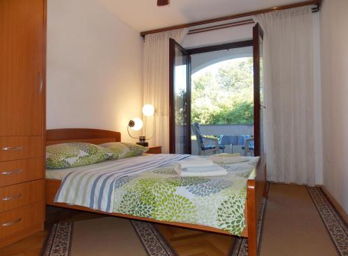 a bedroom with a bed and a large window at Apartments with a parking space Malinska (Krk) - 5353 in Vantačići