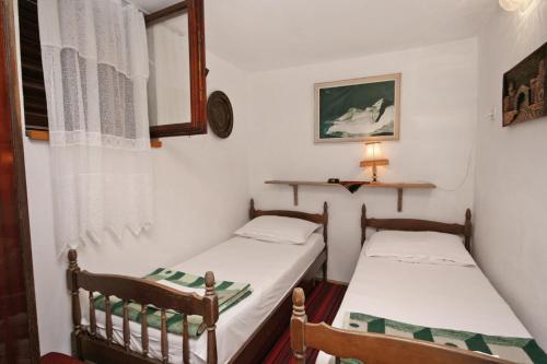 two twin beds in a small room with a lamp at Apartments with a parking space Selce, Crikvenica - 5531 in Selce