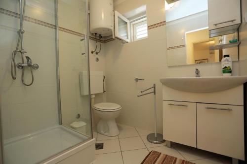 y baño con ducha, aseo y lavamanos. en Apartments with a parking space Supetar, Brac - 5385, en Supetar