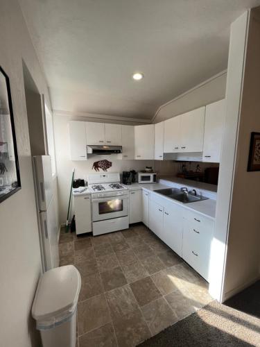 a kitchen with white cabinets and a sink and a stove at June Lake Villager in June Lake