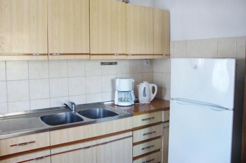 a kitchen with a sink and a white refrigerator at Apartments with a parking space Baska, Krk - 5407 in Baška