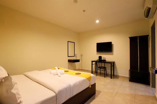 a hotel room with a bed and a flat screen tv at Golden Roof Hotel Falim Ipoh in Ipoh
