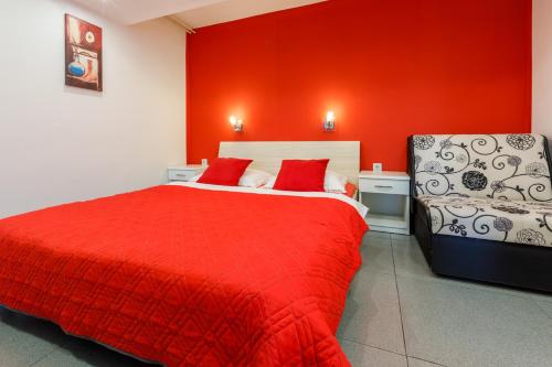 a red bedroom with a bed and a chair at Studio Crikvenica 5478b in Crikvenica
