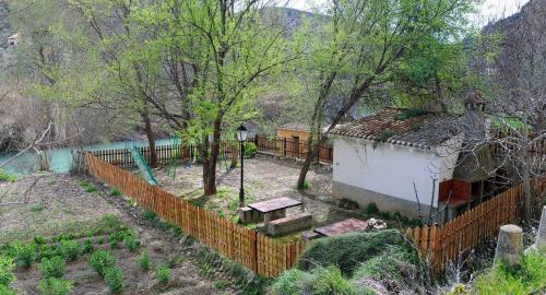 a fence in front of a yard with a building at Casa Rural La Herradura del río Júcar in Jorquera