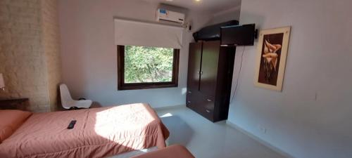 1 dormitorio con cama y ventana.  en nuestra casa en Balneario Mar Azul