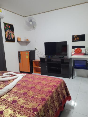 a hotel room with a bed and a flat screen tv at B&B NAMO PHUKET in Kathu