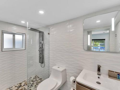 a bathroom with a toilet and a sink and a mirror at 5-star Lakefront Oasis In Hollywood-Hard rock casino in Fort Lauderdale