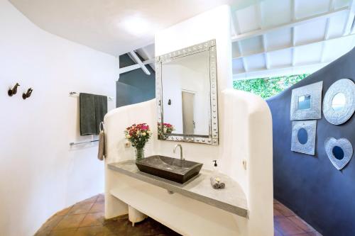 a bathroom with a sink and a mirror at La Villa Oberoi (6 BR) in Seminyak