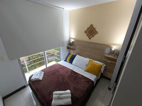 Habitación pequeña con cama y ventana en Apartamento Aroma de Café, en Montenegro