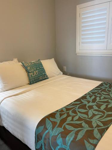 a small bedroom with a bed with a window at The Palomar Inn in Pismo Beach