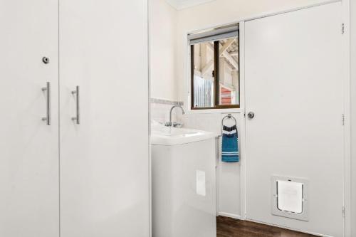 a white bathroom with a sink and a mirror at Panoscape in Sunset Strip