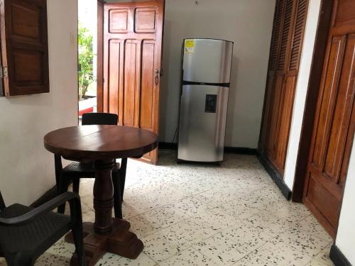 a kitchen with a table and a refrigerator at Hotel Villa Mary Apartaestudios playa in Puerto Colombia