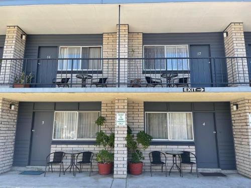 a building with chairs and tables on a balcony at Forster Motor Inn in Forster