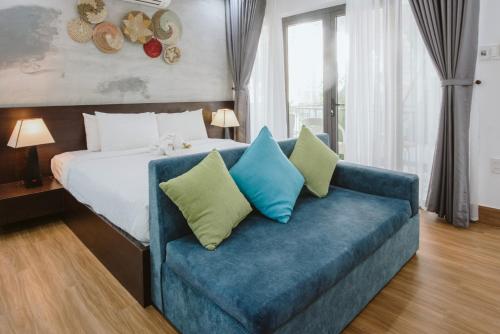 a bedroom with a bed and a blue couch at PHỐ CHỢ ĐÊM Villa - Near Hoi An Old Town 200m in Hoi An