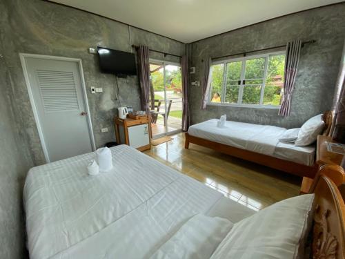 a bedroom with two twin beds and a window at Pruksa View Homestay in Ban Phu Hi