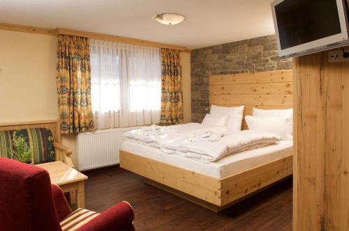 1 dormitorio con 1 cama y TV en la parte superior en Allgäuer Kräuteralm en Oberstaufen