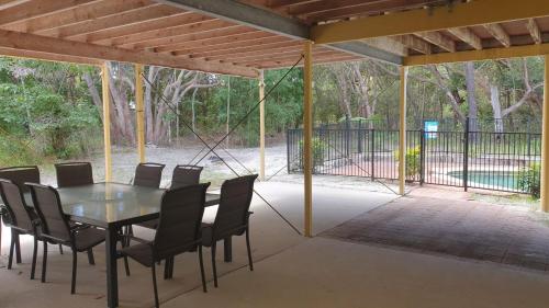 a patio with a table and chairs and a fence at 20 Orania Court in Rainbow Beach