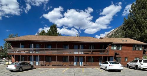 a building with two cars parked in a parking lot at June Lake Villager in June Lake