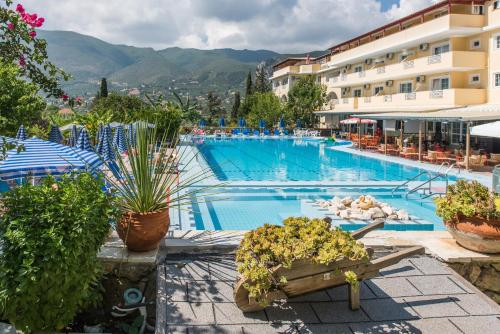 una gran piscina con plantas y edificios en Koukounaria Hotel & Suites, en Alykes