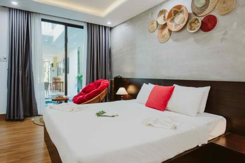 um quarto com uma grande cama branca com almofadas vermelhas em PHỐ CHỢ ĐÊM Villa em Hoi An
