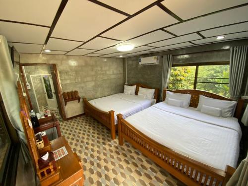 a room with two beds and a mirror at Pruksa View Homestay in Ban Phu Hi