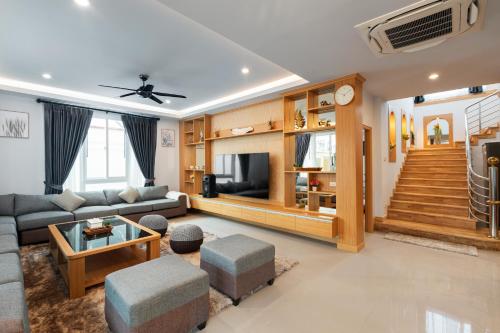 a living room with a couch and a tv at Grand Gala Villa in Pattaya South