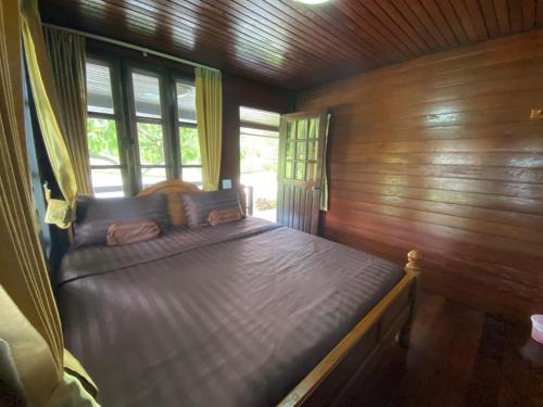 a bedroom with a bed in a wooden cabin at Pruksa View Homestay in Ban Phu Hi