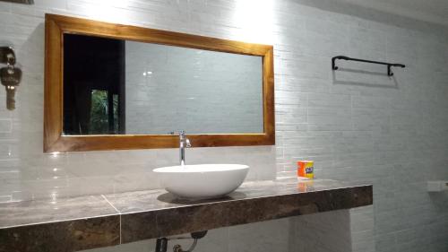 a bathroom with a bowl sink and a mirror at Mulia Home Stay in Nusa Dua