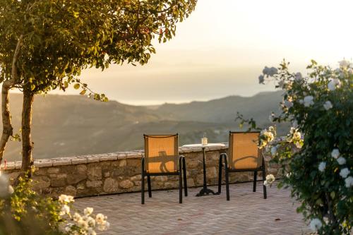 two chairs sitting on top of a stone wall at Gerofotis Traditional Guesthouse est 1892 - Close to Aigio, Akoli, Selianitika in Lákka