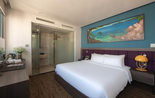 a bedroom with a large white bed and a shower at Aaron Hotel in Nha Trang