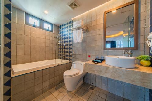 a bathroom with a toilet and a sink and a tub at Aaron Hotel in Nha Trang