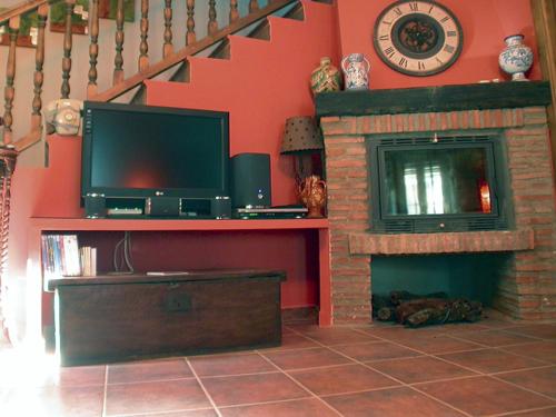 a living room with a tv and a fireplace at Solaz del Ambroz in Jarilla