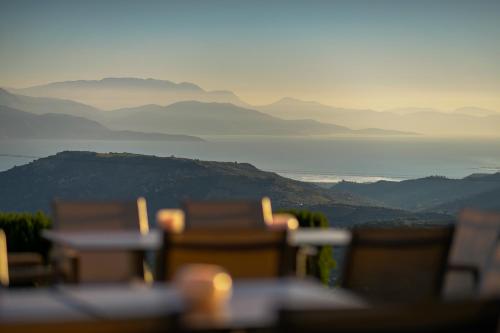 a group of chairs with a view of the water and mountains at Gerofotis Traditional Guesthouse est 1892 - Close to Aigio, Akoli, Selianitika in Lákka