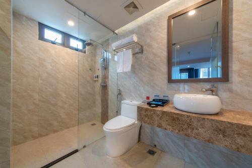 a bathroom with a toilet and a sink and a mirror at Aaron Hotel in Nha Trang