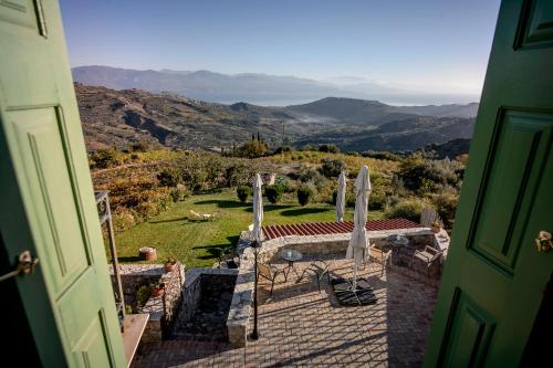 a view from an open door of a house with a garden at Gerofotis Traditional Guesthouse est 1892 - Close to Aigio, Akoli, Selianitika in Lákka