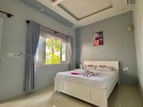 a bedroom with a white bed and a window at Ngoc Hanh Bungalow Phu Quoc in Phu Quoc