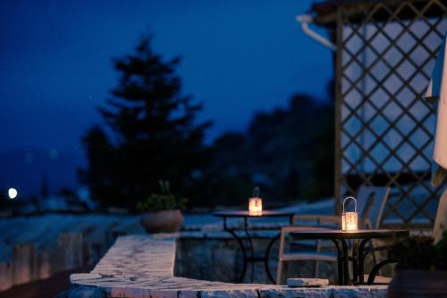 a patio with two tables and a christmas tree at night at Gerofotis Traditional Guesthouse est 1892 - Close to Aigio, Akoli, Selianitika in Lákka
