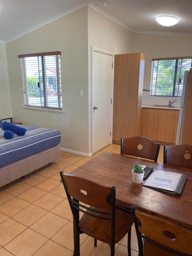 カーナーボンにあるOutback Oasis Caravan Parkのテーブル、椅子、ベッドが備わる客室です。