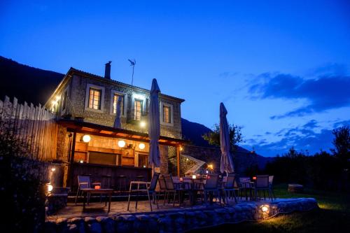a house with a group of tables and chairs at night at Gerofotis Traditional Guesthouse est 1892 - Close to Aigio, Akoli, Selianitika in Lákka