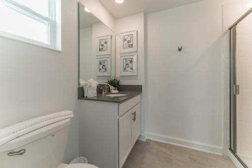 a bathroom with a toilet and a sink and a shower at "Violet Love & Magic" Luxury Villa Storey Lake in Kissimmee