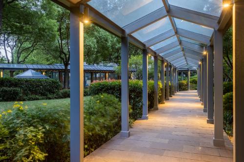 a covered walkway in a garden with lights at Millennium Hotel Wuxi in Wuxi