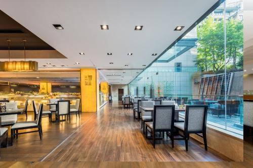 uma área de refeições com mesas e cadeiras num restaurante em Millennium Hotel Wuxi em Wuxi