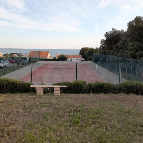 - un court de tennis avec un banc devant dans l'établissement Loralistudios, Maison en bord de mer, à Pornic