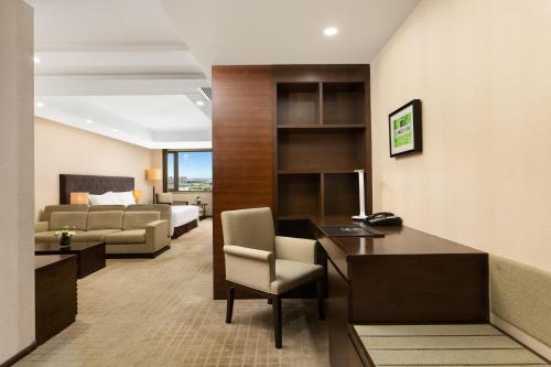 a hotel room with a desk and a bed at Millennium Hotel Wuxi in Wuxi