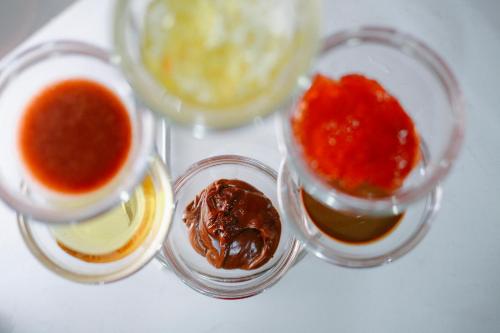 three smalloops of sauce in small glass containers on a table at Pariat River Front Hotel in Da Nang