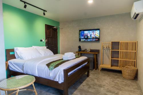 1 dormitorio con 1 cama grande y TV en la pared en Lo-Ha Guest house, Contactless Check-in en Bangkok