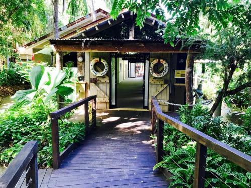 a wooden walkway leading to a house with a green door at Private Hotel Studio Apartment - Full Kitchen in Port Douglas