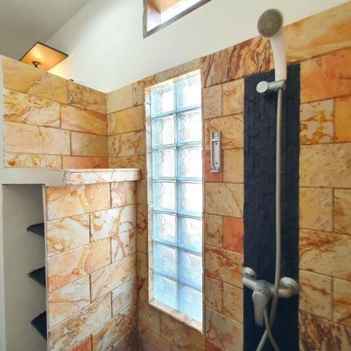 a bathroom with a shower with a window at Putra Boyan Cottages in Gili Trawangan