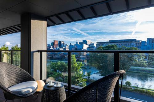 a balcony with two chairs and a view of the city at Rinn Gion Shirakawa in Kyoto