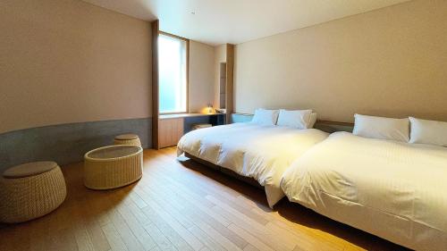 a hotel room with two beds and a window at kamakura seizan in Kamakura